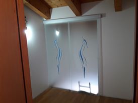 Art vertice blu installato su piano mansardato realizzato su misura porta scorrevole porta arzignano vetreria vicenza vetreria verona ristrutturazione casa vetro design serglas glasstyle e a scrigno doppie porta doppia eclisse porte in vristallo vetreria